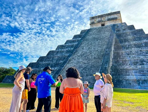 Guida che conduce un gruppo tra le rovine di Chichen Itza nel tour da Cancun